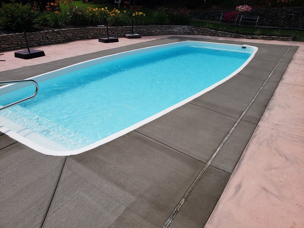 Freshly dried concrete pad around a swimming pool